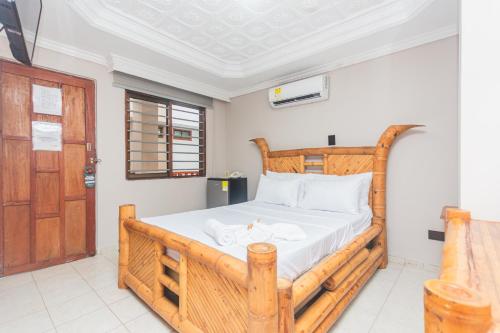 a bedroom with a wooden bed and a wooden door at Hotel Baluarte Cartagena Boutique in Cartagena de Indias