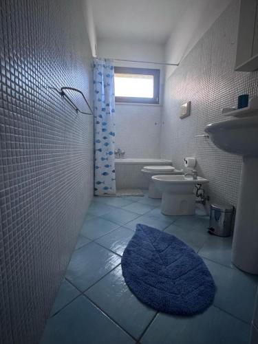 a bathroom with a sink and a blue rug at La Casa di Viola, appartamento con aria condizionata in Sirolo