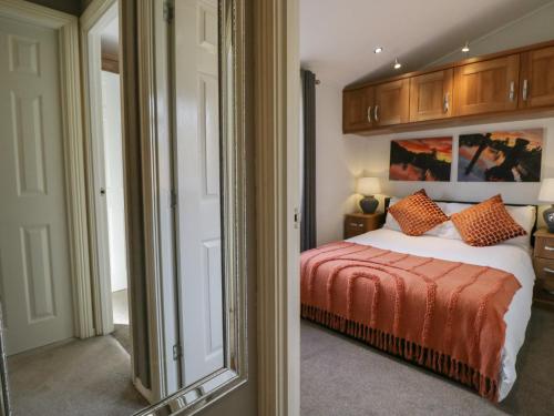 a bedroom with a large bed and a mirror at Gressingham View Lodge in Carnforth