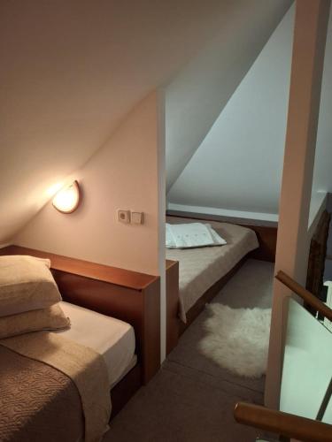 a attic room with two beds and a mirror at VILLA GOLF Crystal Drop Apartment in Rogaška Slatina