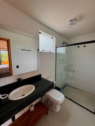 a bathroom with a sink and a toilet and a shower at Cabana Bariloche - Busch Camping in Rancho Queimado