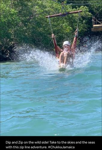 a man in the water on a rope in the water at Skyline Suites Villa and Spa in Montego Bay