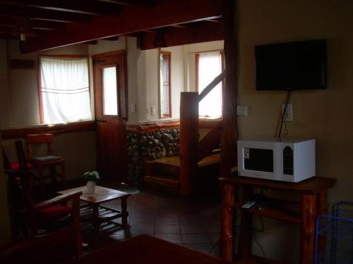 a living room with a tv and a microwave at Cabaña Un Mundo nuevo in San Carlos de Bariloche