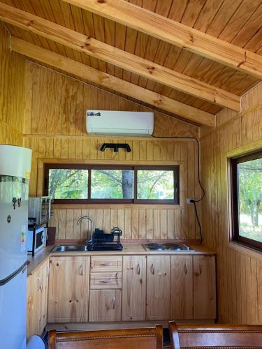 a kitchen with a sink and a refrigerator in a cabin at Comodidad y Hermosa Vista Volcán in Melipeuco