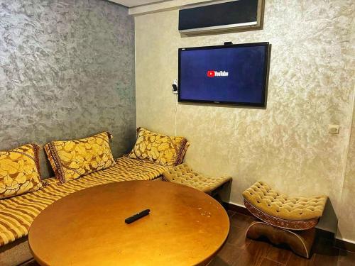 a room with a couch and a table and a tv at Oceanda Appart N1 Agadir in Agadir