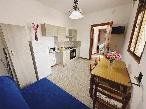 a kitchen with a table and a blue couch in a room at Villa Nausica fronte mare - A in Torre Lapillo