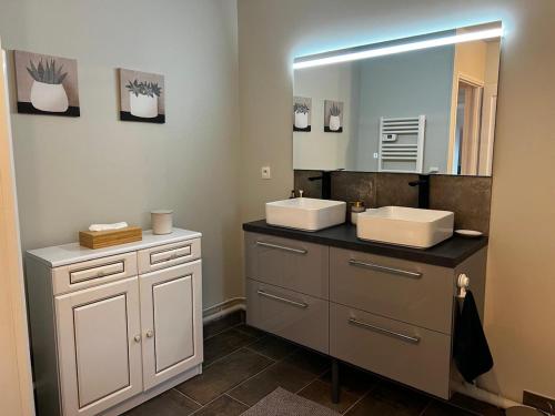 une salle de bain avec deux lavabos et un grand miroir dans l'établissement Maison de vacances cosy à 5mn de la plage, à Merville-Franceville-Plage