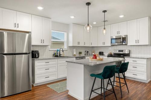 a kitchen with white cabinets and a stainless steel refrigerator at Caroline in Granbury