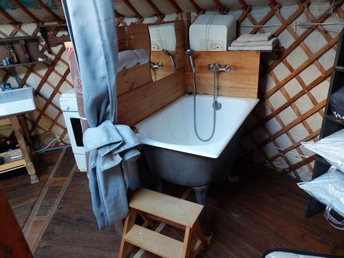 a bathroom with a tub and a sink in a yurt at La yourte au cœur de la Normandie in Boudeville