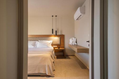 a bedroom with a bed and a nightstand with a bed sidx sidx sidx sidx at Anemelia Villas in Karpathos Town