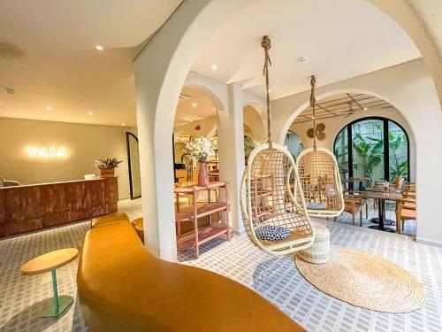 a lobby with rattan chairs and a table at Vaia Hoi An Boutique Hotel in Hoi An
