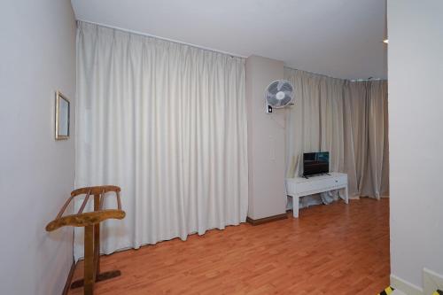 a living room with white curtains and a television at New Bangi Gateway Hotel in Bangi