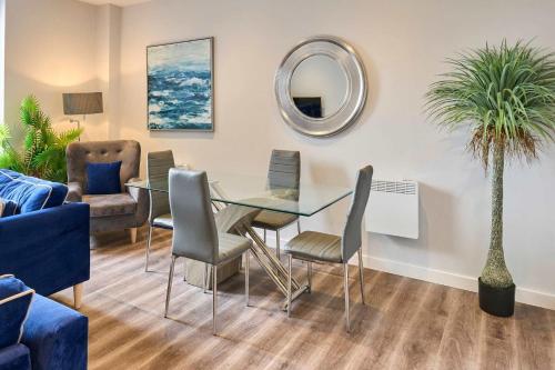 a dining room with a glass table and chairs at Host & Stay - Crosby Gardens Apartment in Crosby