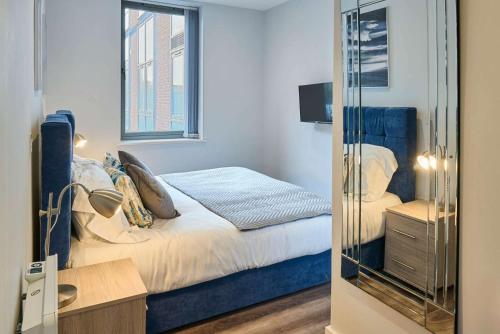 a small bedroom with a bed and a mirror at Host & Stay - Crosby Gardens Apartment in Crosby