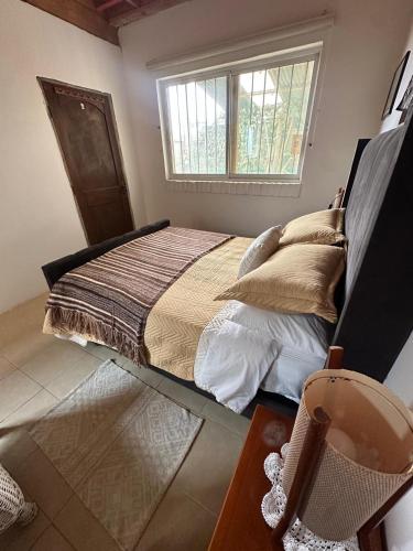 a bedroom with a bed with pillows and a window at Doña Patty in El Tabo