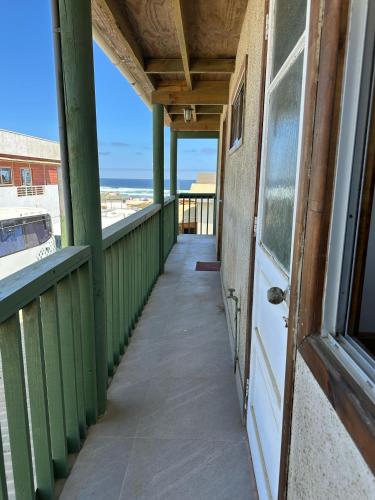 a balcony with a door and a view of the ocean at Doña Patty in El Tabo
