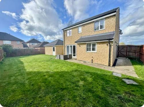 a brick house with a lawn in front of it at Elysian Escape, modern 5 bedroom house in Darlington