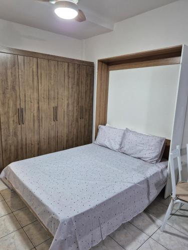 a bedroom with a bed with wooden cabinets at Cantinho do Sol e Mar in São Vicente