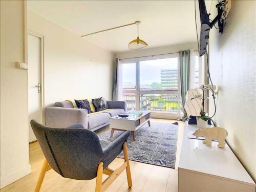 salon z kanapą i stołem w obiekcie Idéal Groupe - Grands Espaces - 4 chambres - Parking Gratuit - Proche Centre, Gare & Transports - Wifi - OFFRE SPECIAL de Reduction jusqu'à -50 w mieście Le Mans