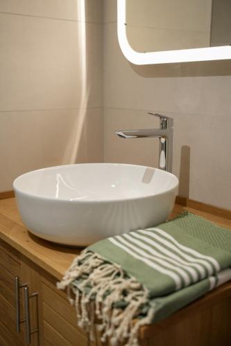 - un lavabo blanc assis sur un comptoir dans la salle de bains dans l'établissement Les Hauts de Bergheim, à Bergheim