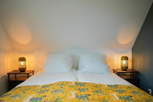 - une chambre avec un lit et deux lampes de chaque côté dans l'établissement Les Hauts de Bergheim, à Bergheim