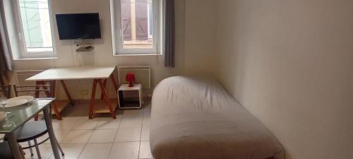 - une chambre avec un lit, une table et une fenêtre dans l'établissement studio zen, à Narbonne