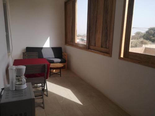 a room with a table and chairs and two windows at Florecita 2 in Ngaring