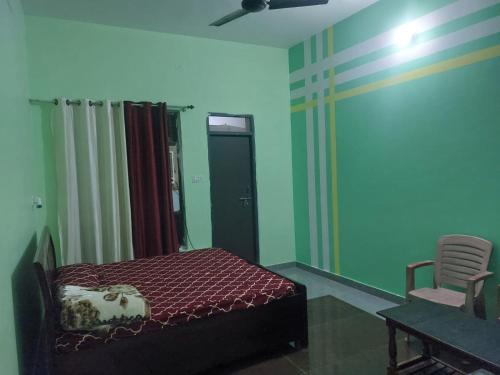 a bedroom with a bed and a chair in it at aditya homestay in Faizābād