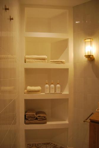 a bathroom with white shelves and towels at Natural Ambience apartment NEW in St. Paul's Bay