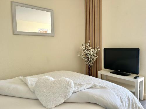 - une chambre avec un oreiller pour le cœur sur un lit dans l'établissement Petit Tourangeau - Jardin Botanique - Balcon, à La Riche