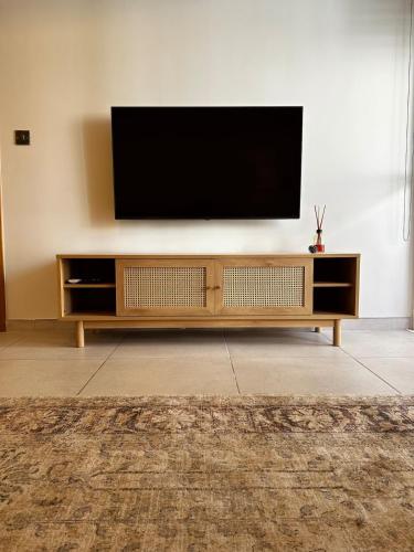 a flat screen tv sitting on top of a wooden entertainment center at Natural Ambience apartment NEW in St. Paul's Bay