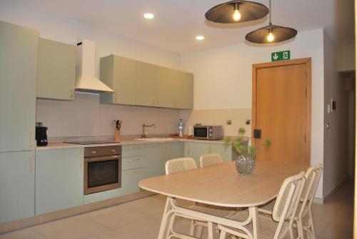 a kitchen with a wooden table and a table and chairs at Natural Ambience apartment NEW in St. Paul's Bay