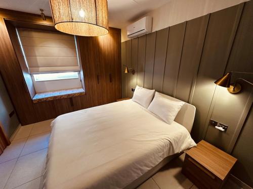a bedroom with a white bed and a window at Natural Ambience apartment NEW in St. Paul's Bay