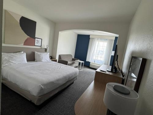 a hotel room with a bed and a chair at Spark by Hilton Opelousas in Opelousas