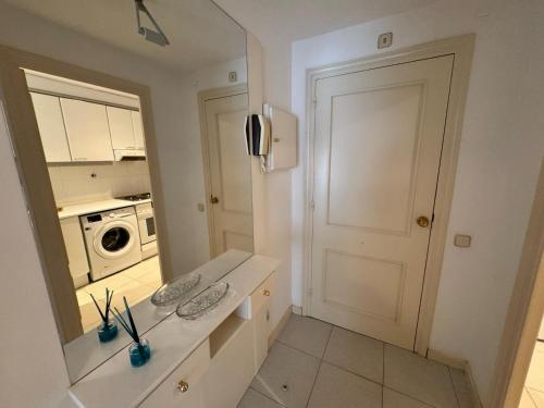 una cucina bianca con porta e forno a microonde di Apartamento a 100 metros de la playa con aire acon a Tossa de Mar