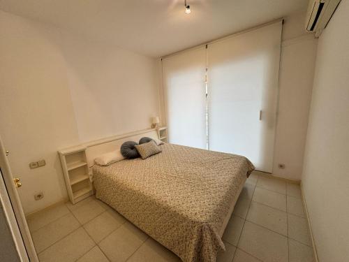 una camera da letto con un letto con due cuscini sopra di Apartamento a 100 metros de la playa con aire acon a Tossa de Mar