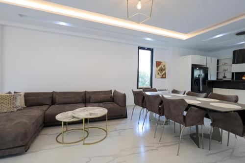 a living room with a couch and a table and chairs at SanPietro Premium Villas in Draçi