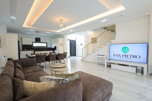 a living room with a couch and a big screen at SanPietro Premium Villas in Draçi