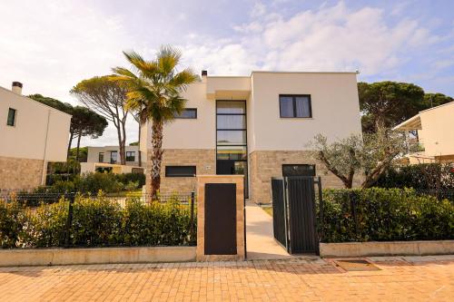 a house with a palm tree in front of it at SanPietro Premium Villas in Draçi