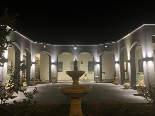 a fountain in the middle of a courtyard at night at בסנדלים: חאן בוטיק בגולן in Ma'ale Gamla