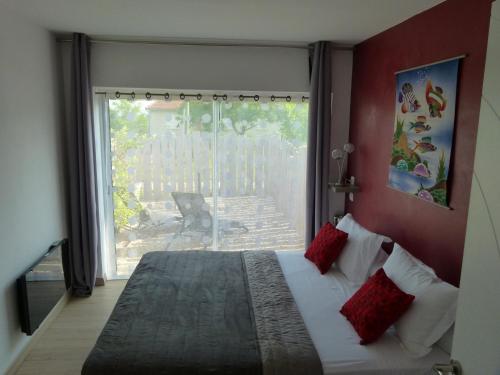 une chambre avec un lit et une grande fenêtre dans l'établissement Chambre d'hôtes du Pilou, à Queyssac-les-Vignes