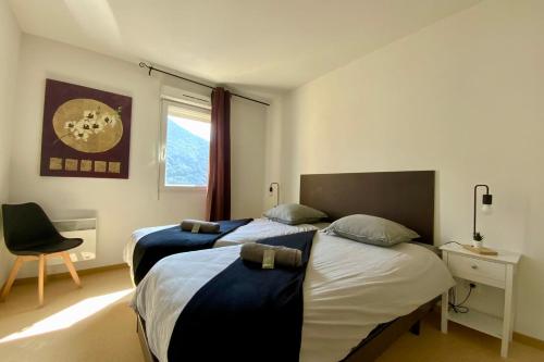 a bedroom with two beds and a chair and a window at Les Naïades C14 - 2 bedrooms for 6 people ! in Avène