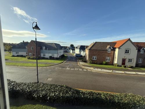 an empty street with houses and a street light at Apartment Ivy - Part of the The Bay Filey Holiday Village with pool, gym and direct beach access, pub, restaurant, tennis and meadows walks in Filey