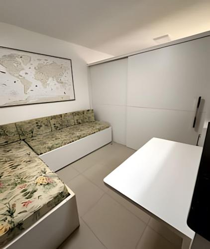 a white room with two beds and a table at Jubiabá - 214C - Vista Mar in Ilhéus