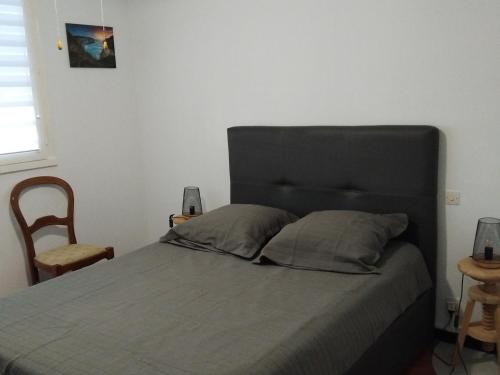 une chambre avec un lit avec une tête de lit noire dans l'établissement Appartement 2 étoiles proche du stade et des Thermes à Balaruc-les-Bains, avec parking et balcon fermé - FR-1-503-84, à Balaruc-les-Bains