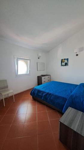 a bedroom with a blue bed and a table at Mamma Wanda Sea View Home Amalfi Coast in Vietri sul Mare