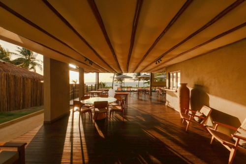 a restaurant with tables and chairs on a patio at Pousada Tatuá in Pôrto de Pedras