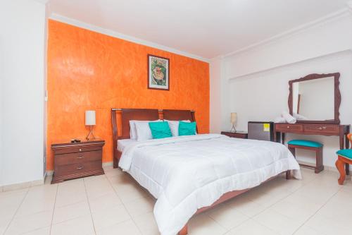 a bedroom with a bed and a dresser and a mirror at Hotel Baluarte Cartagena Boutique in Cartagena de Indias