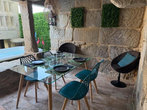 a glass table and chairs on a patio at La Casa del Horreo in Combarro