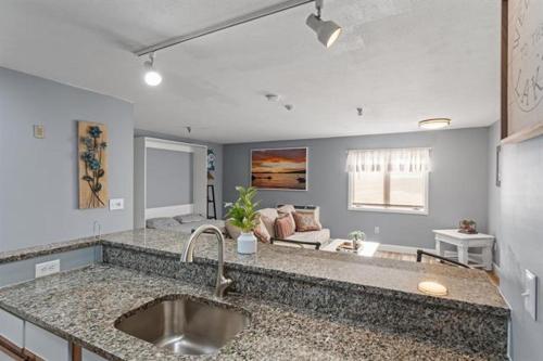 a kitchen with a sink and a living room at The Village at Paugus Bay Condo! in Laconia